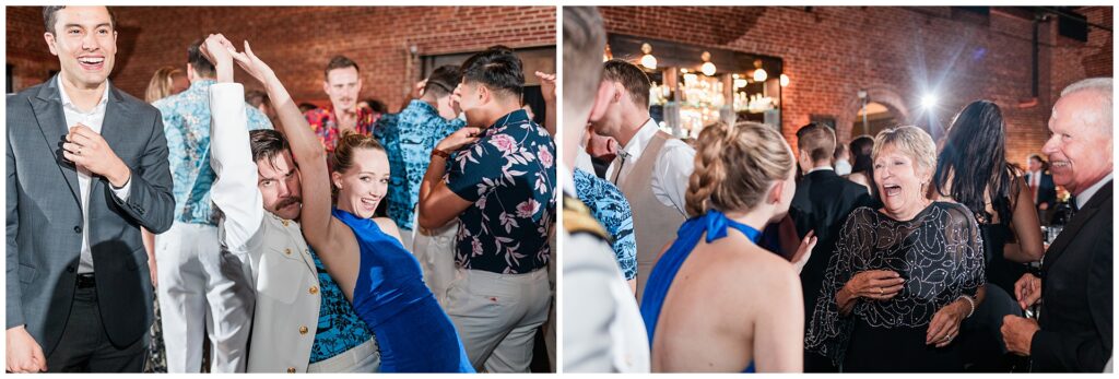 Wedding guests dancing at military wedding reception at historic brick venue with elegant chandeliers.