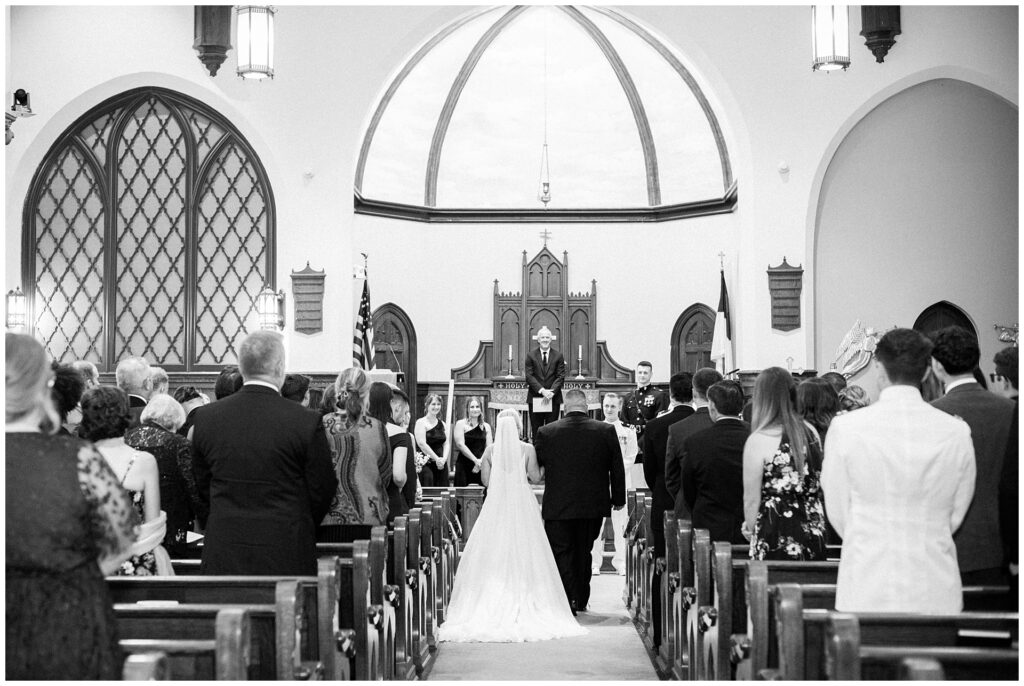 Father walking his daughter down the aisle in a classic black and white wedding ceremony in historic Frederick church with bride in ballgown