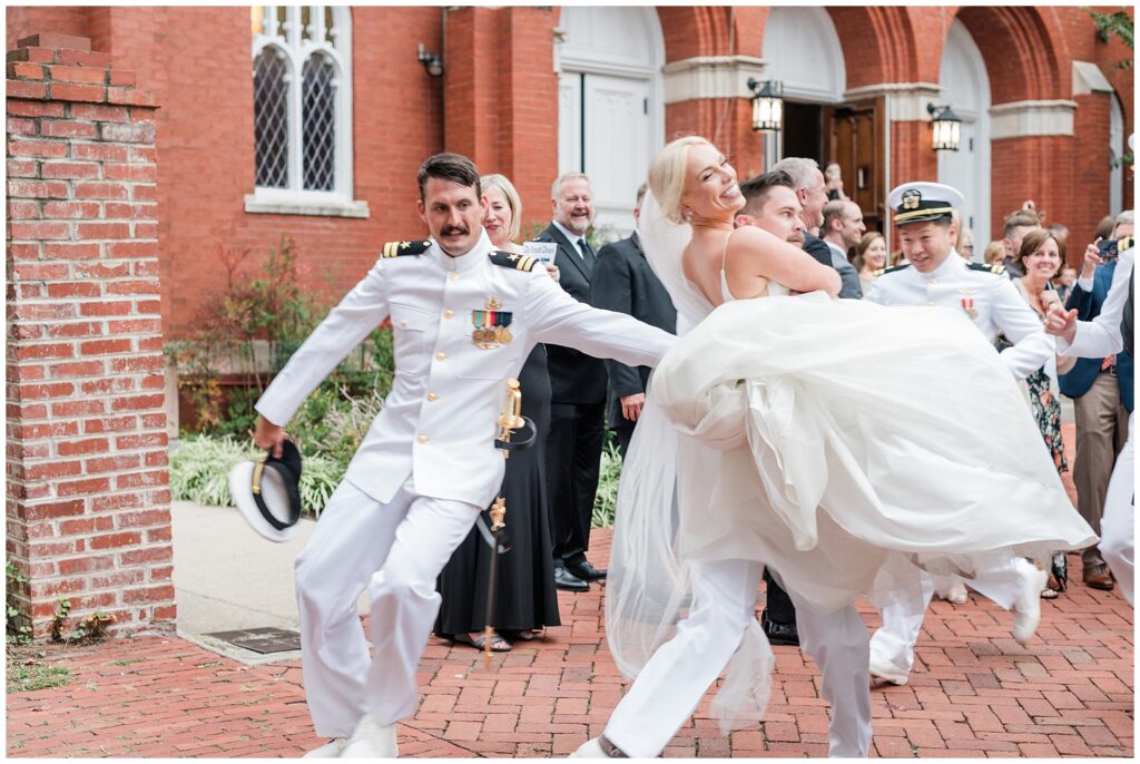 Naval officers stealing the bride after church wedding, playful military wedding tradition in downtown Frederick