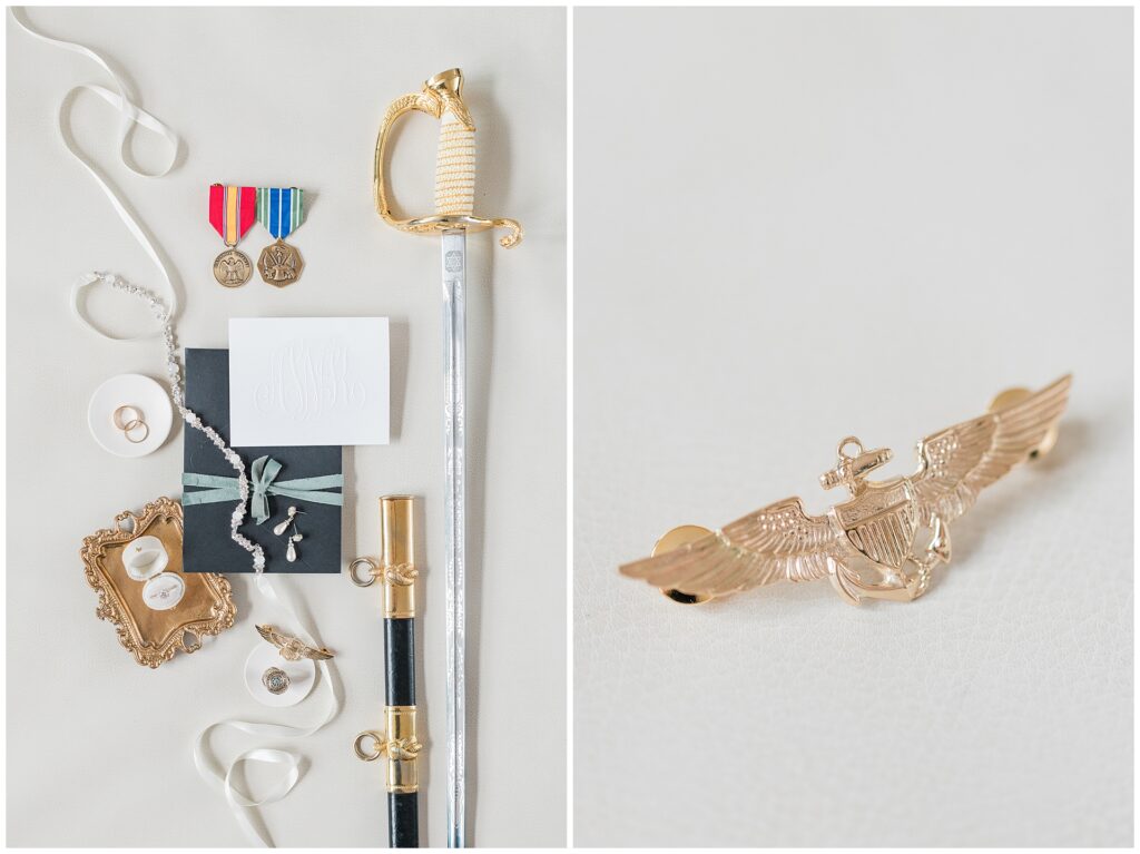 Naval ceremonial sword, aviator wings, and military medals arranged with wedding rings and invitation