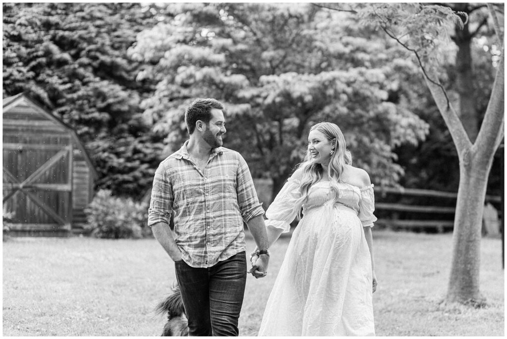 Mom and dad laugh together during their backyard maternity session in Gaithersburg, MD, photographed by a Maryland maternity photographer.