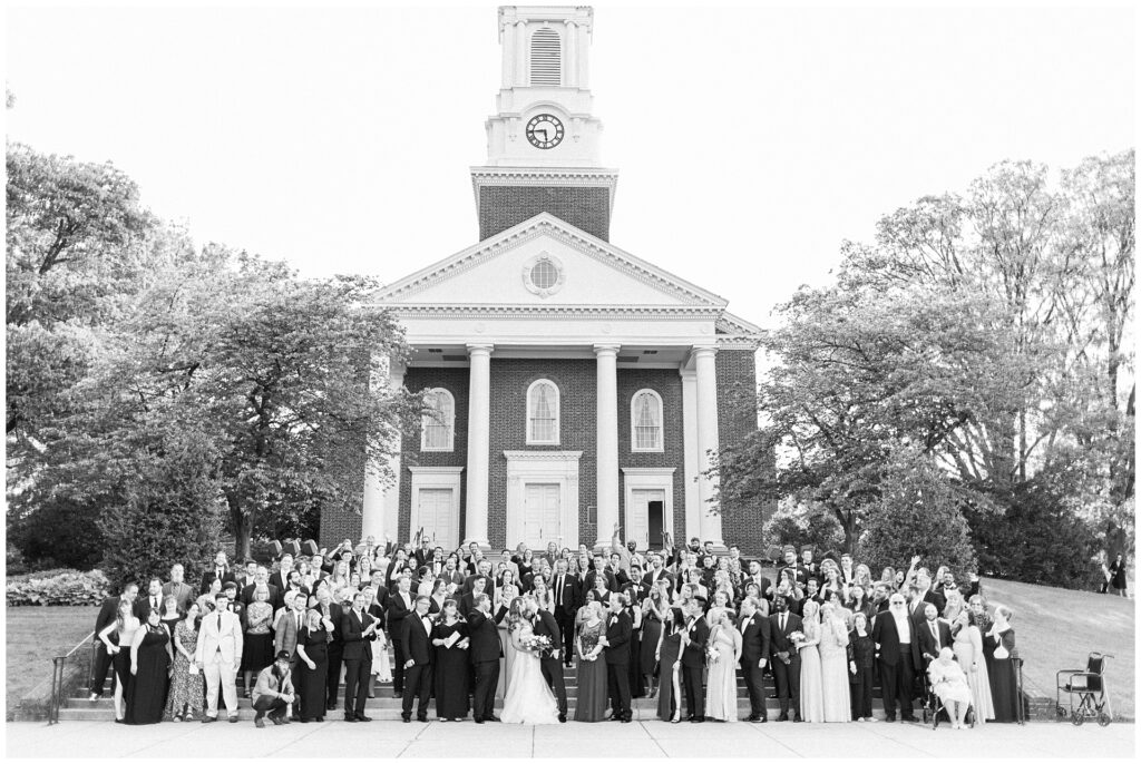 Large group portrait of wedding guests in front of University of Maryland chapel, demonstrating full-day timeline coverage for extended group photos

