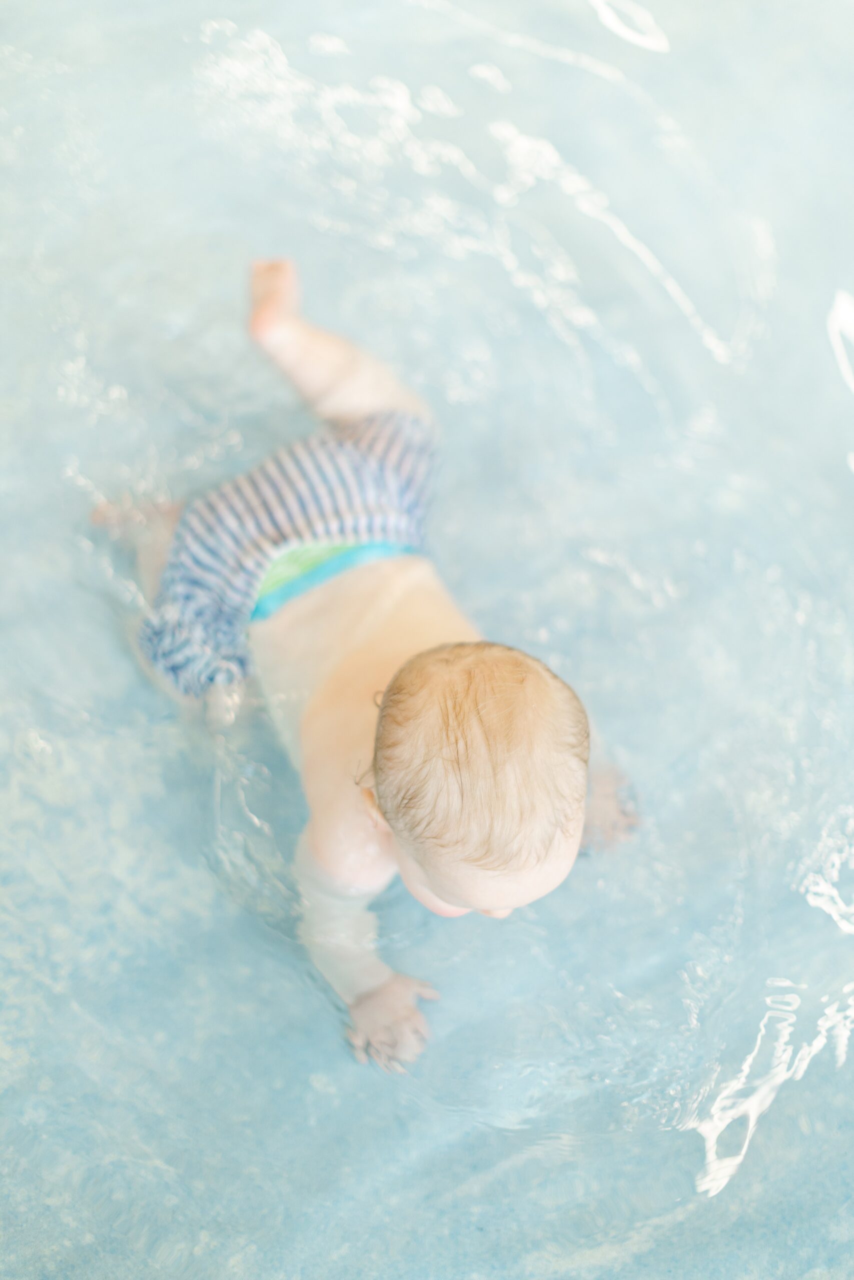 Baby crawling in pool at Life Time in Columbia Maryland during a portrait session