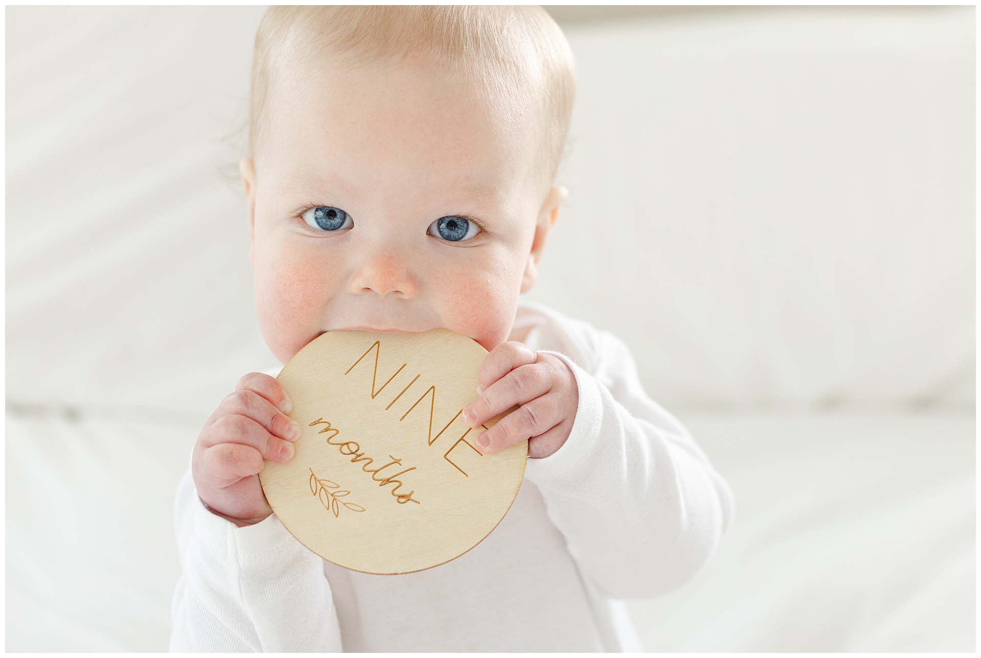Nine-month milestone photo of baby with minimal styling and natural window light in Maryland