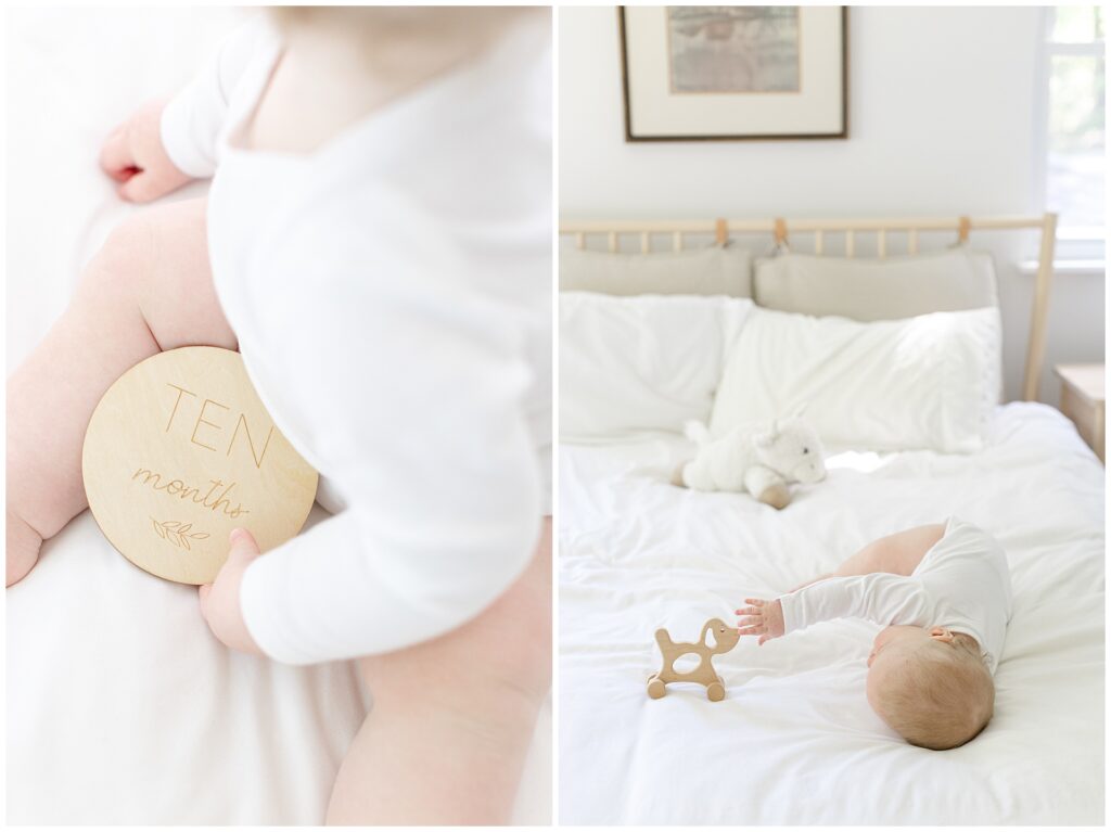 Ten-month-old baby in classic white onesie for at-home milestone portrait on bed with Blizzard