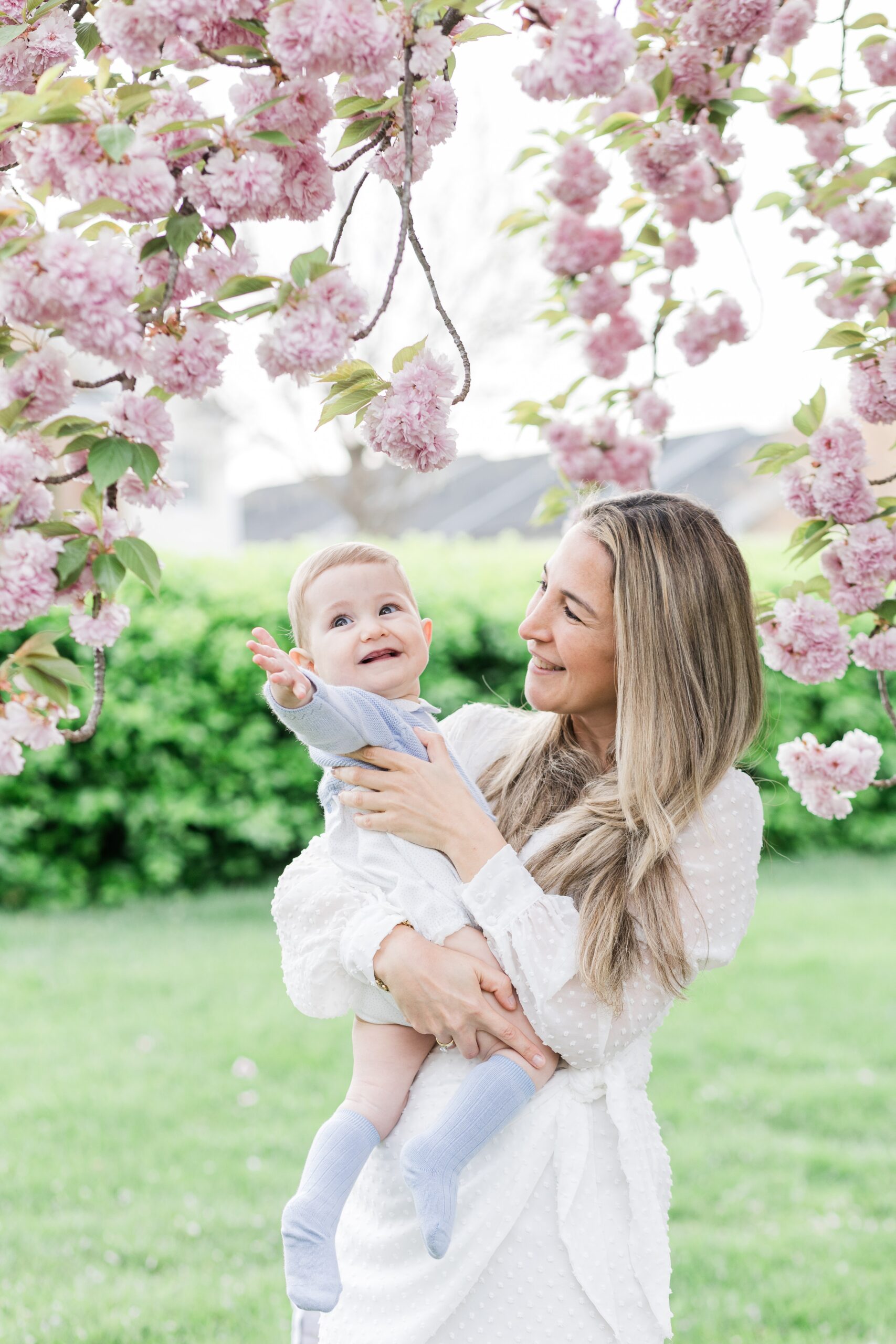 Mother holds her baby during their Howard County Cherry blossom mini session.