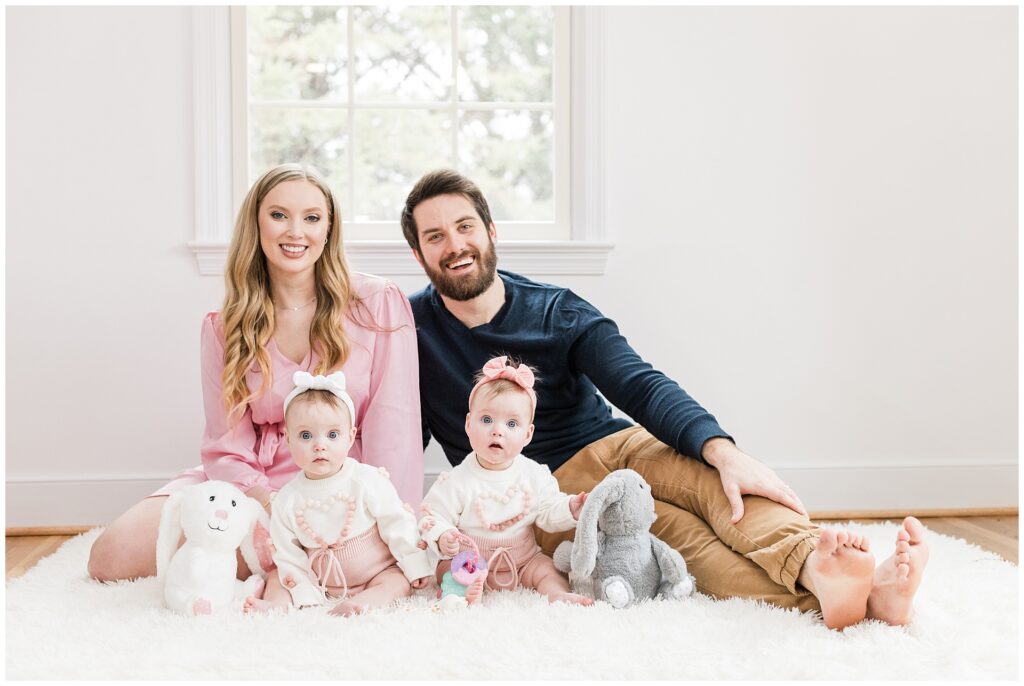 Parents with twin daughters during a six-month lifestyle family session at home in Gaithersburg, Maryland, by a Montgomery County family photographer.
