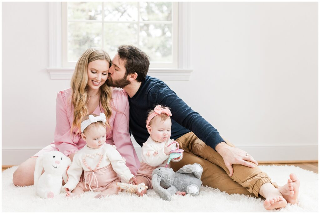 Parents with twin daughters during a six-month lifestyle family session at home in Gaithersburg, Maryland, by a Montgomery County family photographer.