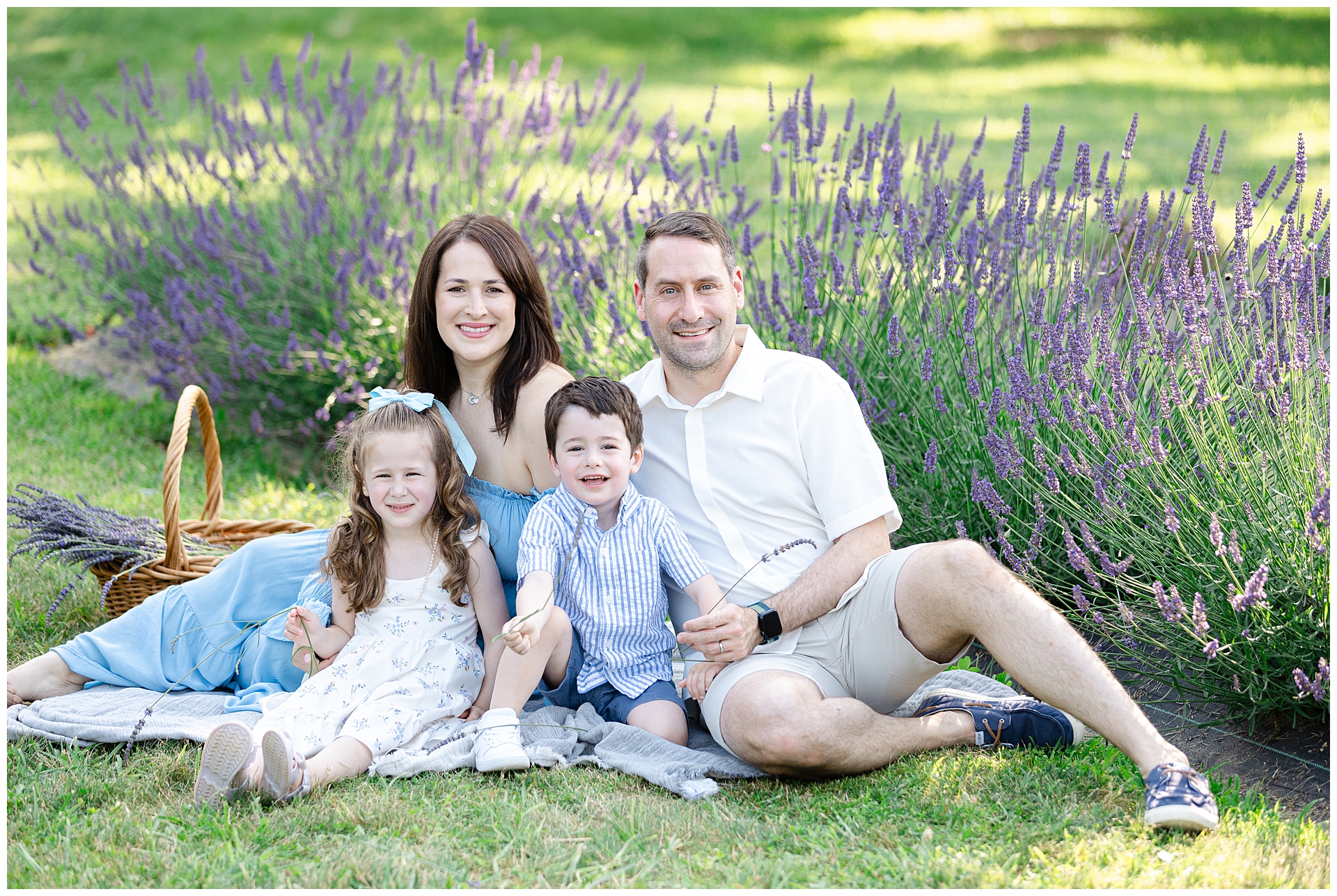 Parents with 2 young children during Montgomery County mini session at Karis Lavender Farm; mother wearing blue dress perfect for a summer lavender session with children