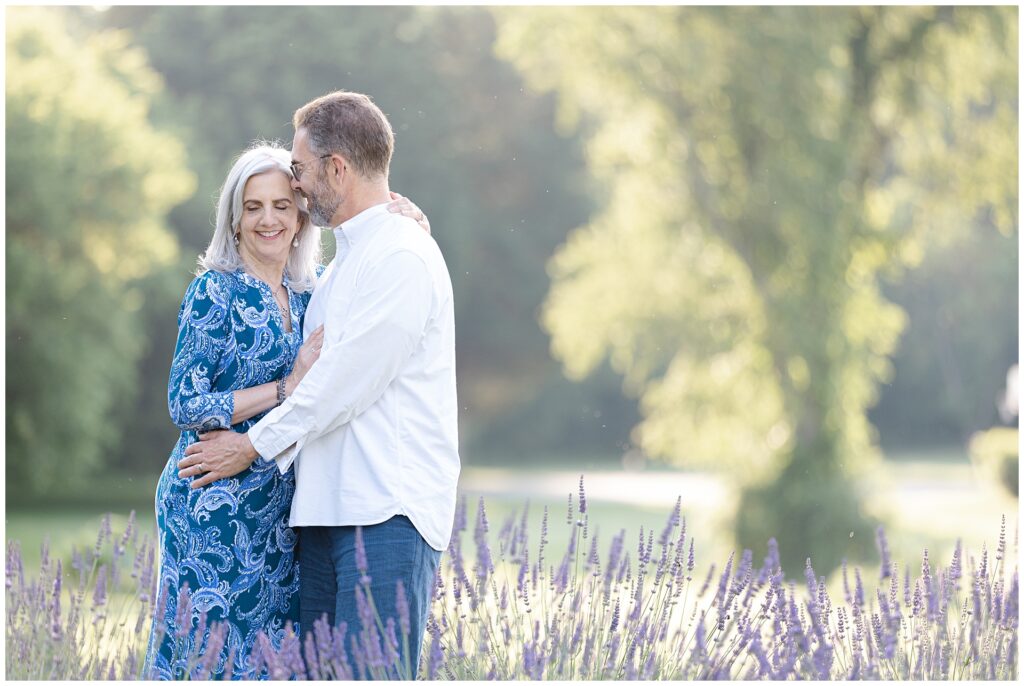 Lavender softly framing couple at a Maryland mini session, with backlighting and natural connection; editorial-style photo perfect for celebrating newlywed life or anniversary portraits outdoors