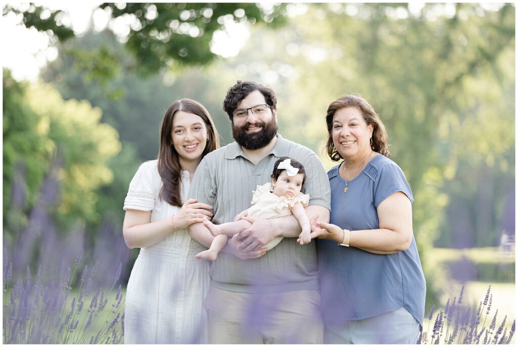 Three generations photographed together during Karis Lavender Farm mini session; infant with parents and grandmother framed by lavender rows for timeless family legacy portraits