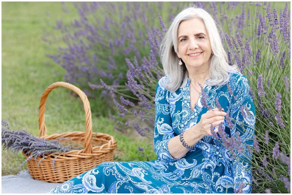 Portrait of woman in flowing blue paisley-print dress at Karis Lavender Farm; bold yet timeless styling choice for mature women attending a summer photo session in Maryland