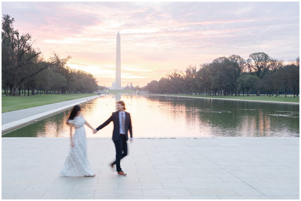 Motion blur engagement photo in Washington DC engagement session at the Reflecting Pool during sunrise, part of a photographer’s guide to planning monument engagement photos.