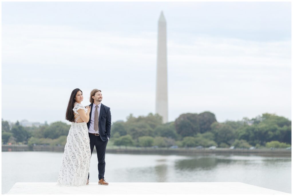 Couple posing for an editorial image in front of the Washington Monument and tidal basin during their DC engagement session