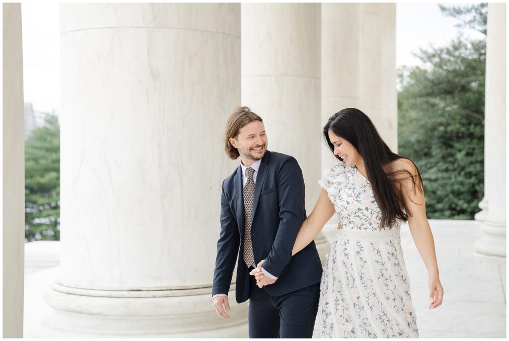 Candid playful image of couple at the Jefferson Memorial  during an engagement session in Washington DC, featuring timeless monument portraits from a local photographer’s planning guide