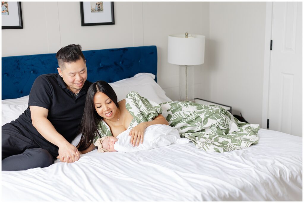 Parents with newborn during an in-home newborn session in Ashburn Virginia bedroom