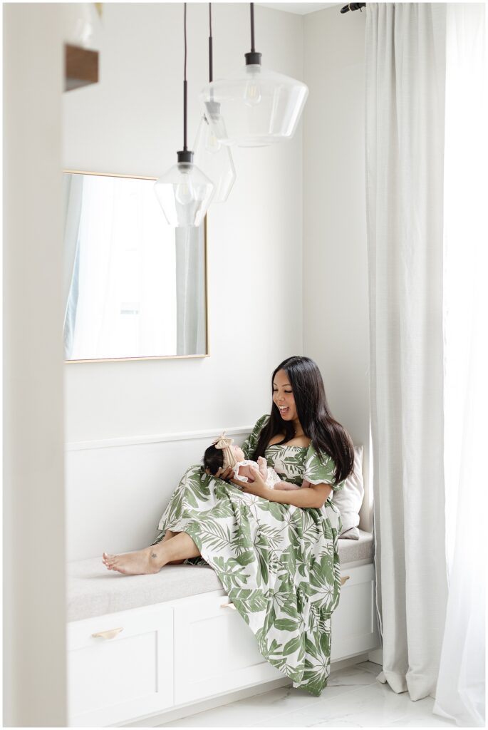 Mother and newborn sitting on built-in bench during an in-home newborn session in Ashburn Virginia