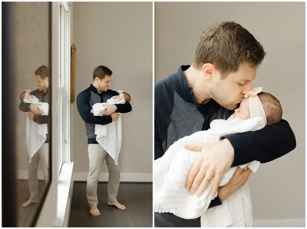 Dad in a blue sweater holds his baby girl in their newborn home session. He gives her a kiss on her forehead in their Virginia newborn session