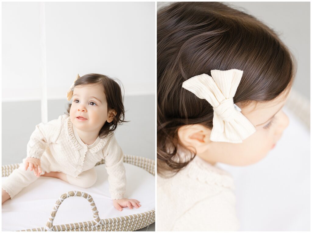 Close-up portrait of a one-year-old girl in a soft oatmeal sweater and bow during first birthday photos in Annapolis