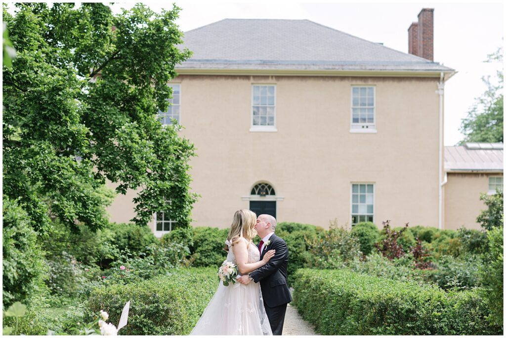 Couple kissing int he back garden of the Tudor Place in the garden
