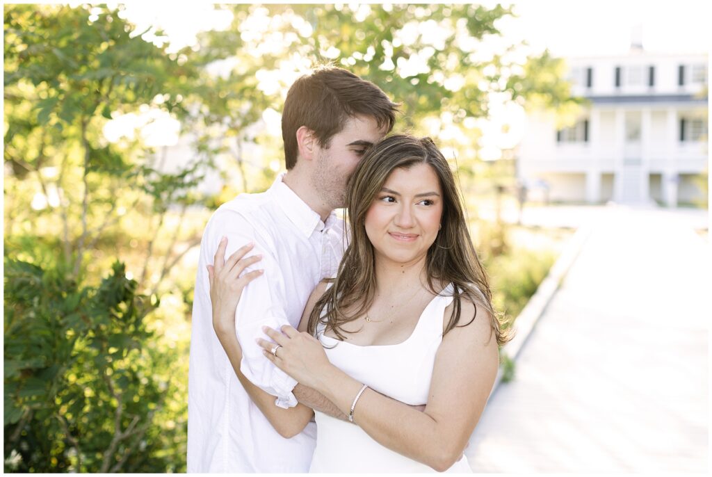 Romantic golden hour beach engagement photos in Maryland of couple cuddling on a pier